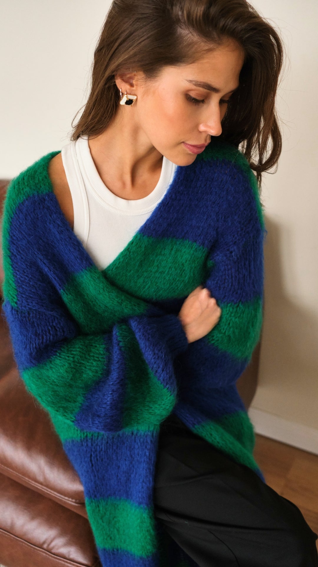 oversized striped cardigan in vibrant blue and green over a white tank top