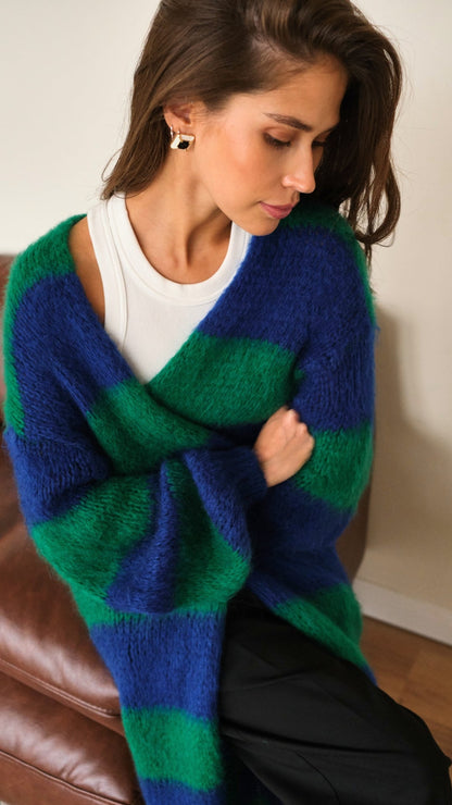 oversized striped cardigan in vibrant blue and green over a white tank top