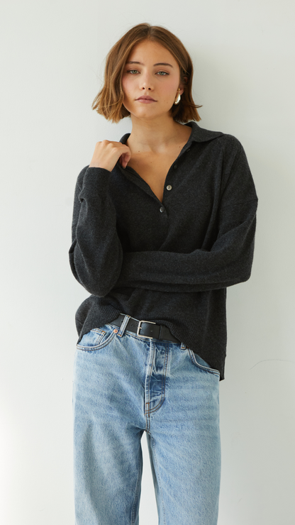 dark grey collared sweater with button details, paired with light blue jeans and a black belt